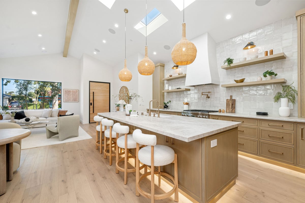 Modern luxury kitchen with wooden cabinets, stone island countertop, and pendant lighting