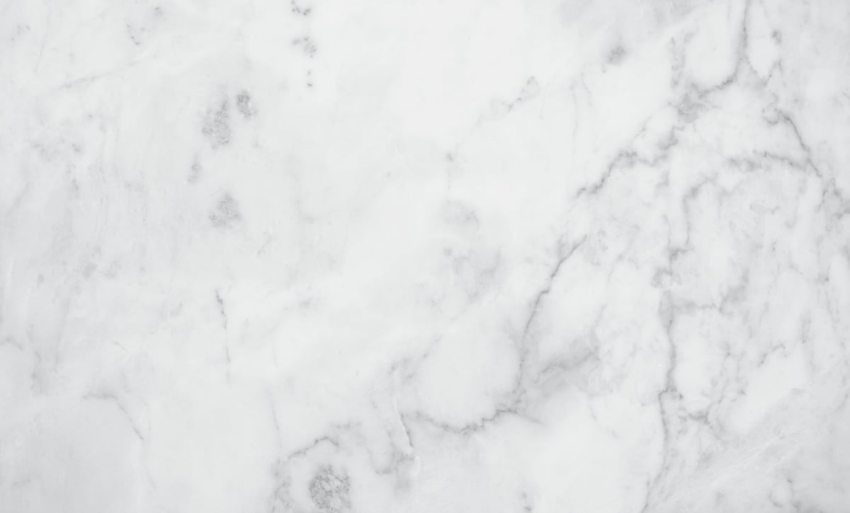 Polished white marble slab with grey abstract veining, viewed from above