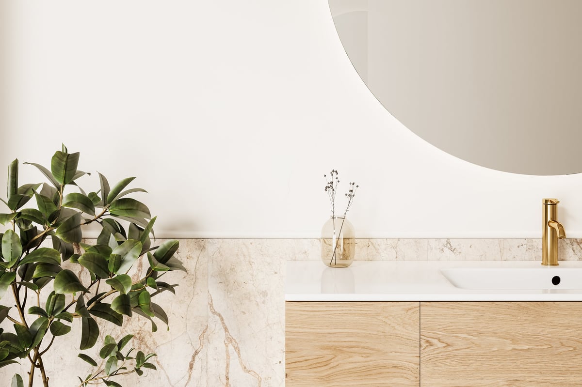 Close-up of a premium wooden vanity with a gold faucet and stone countertop